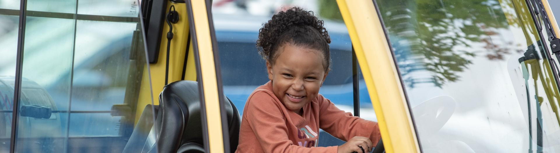 Smiling child in a truck.