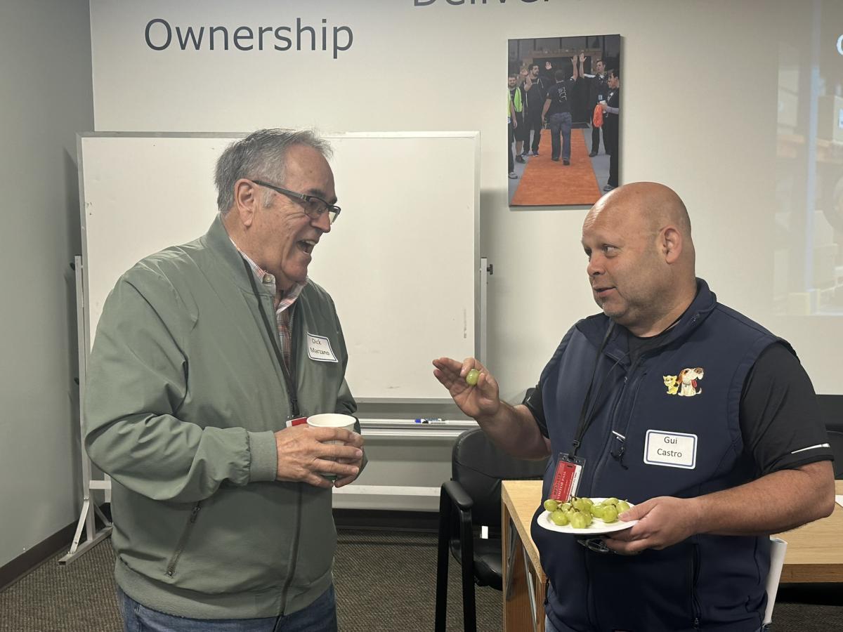 Two men talking to each other over coffee.