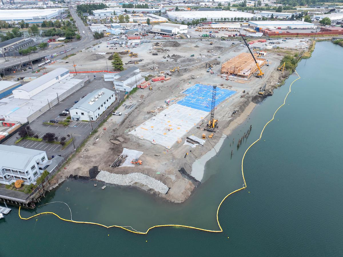 Drone footage of construction happening along a body of water.